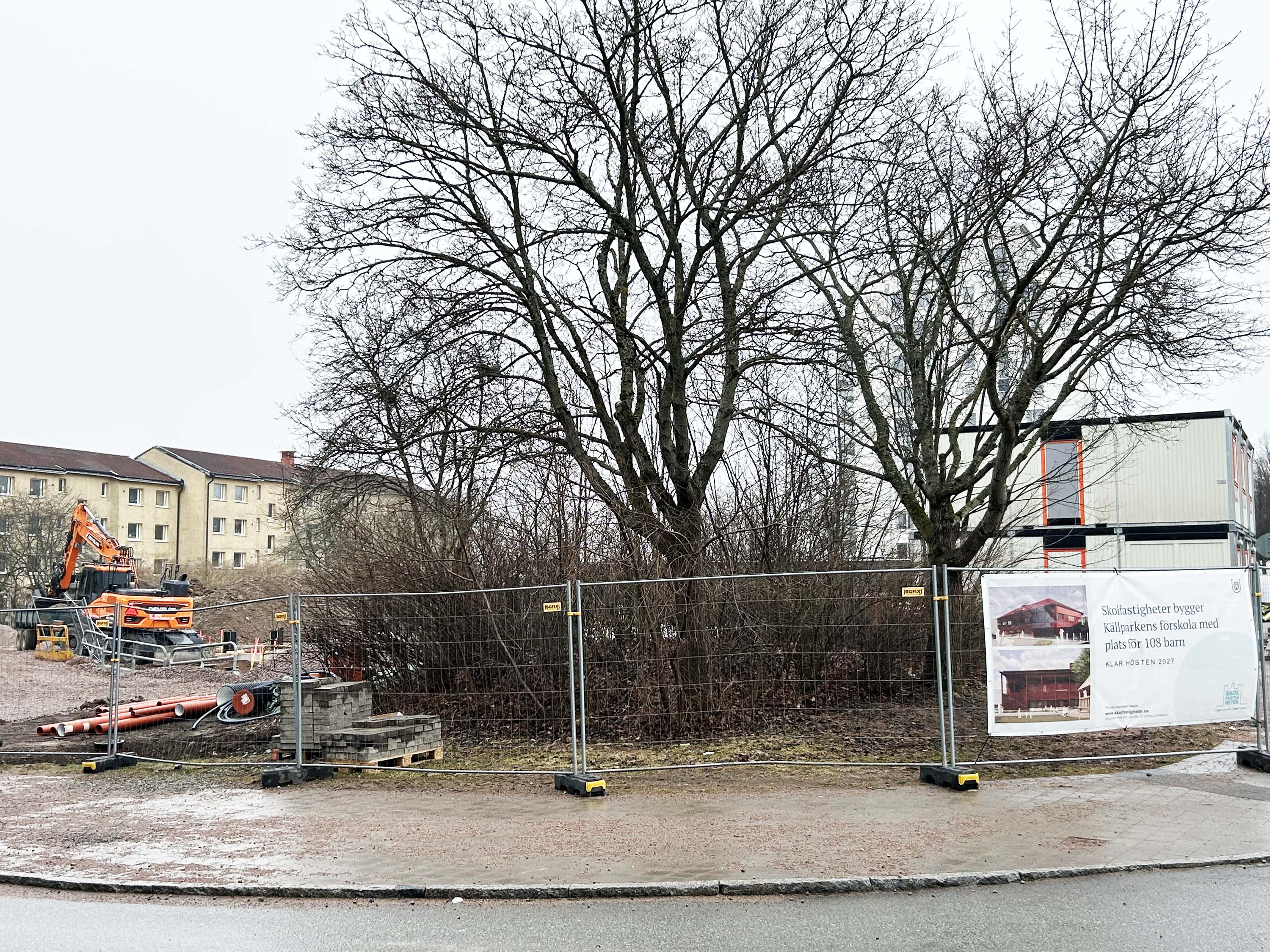 Inhägnad byggplats med vepa på stängsel.