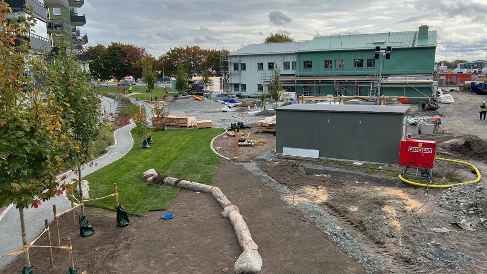 En ny förskola i trä med förskolegård som byggs i ett lägenhetsområde.