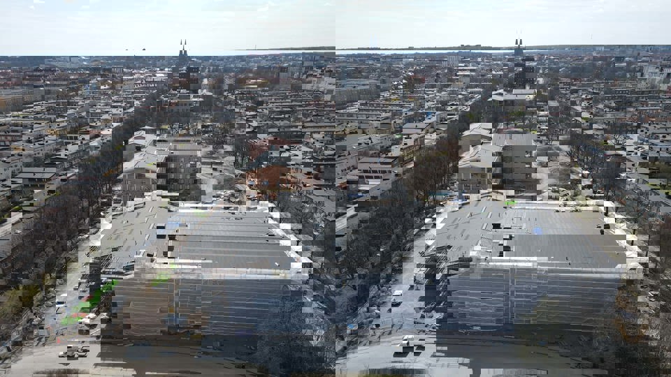 Flygbild över byggplats med omgivande bebyggelse