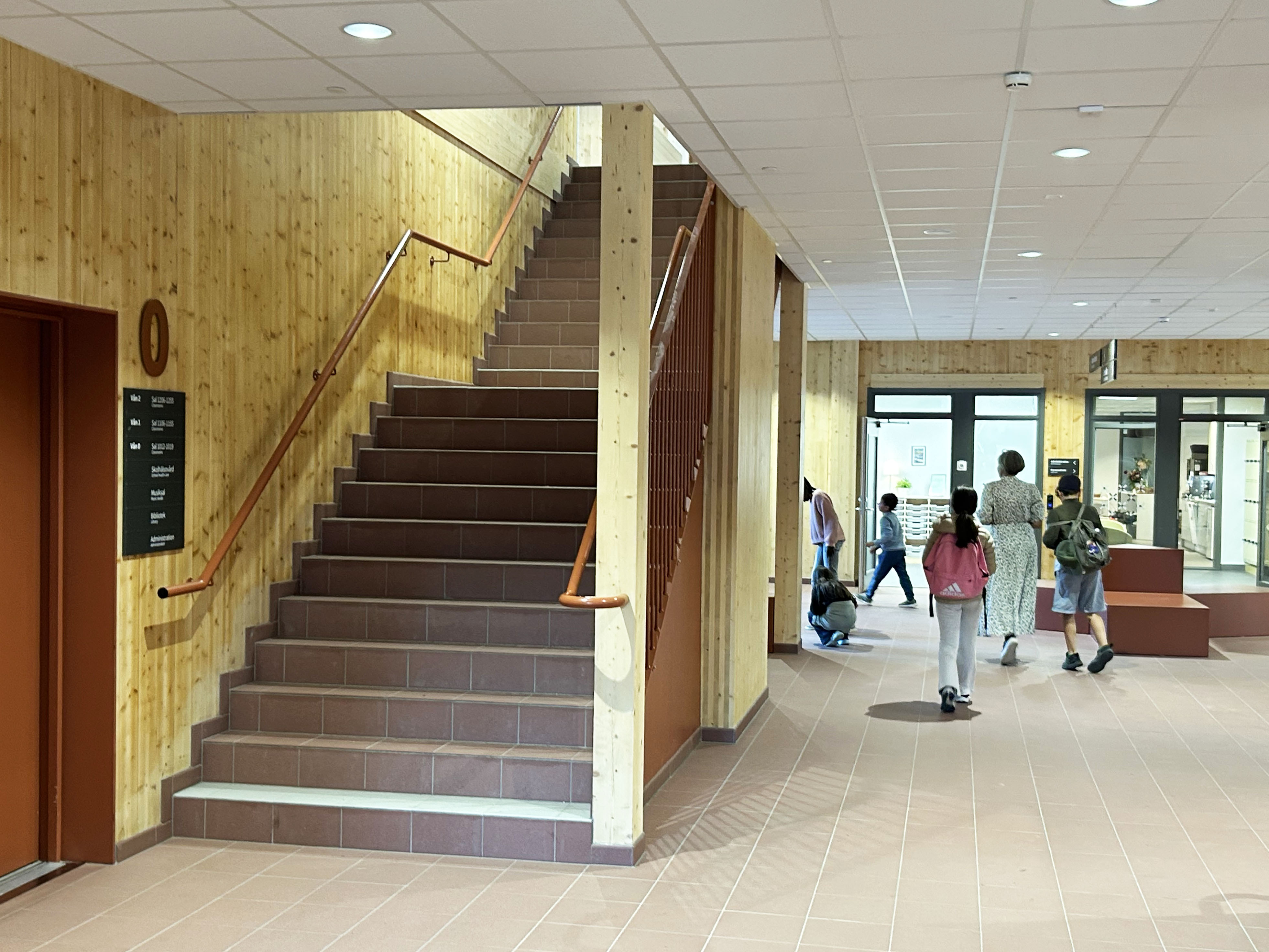 Trapphus i nybyggd skola med barn i bakgrunden.