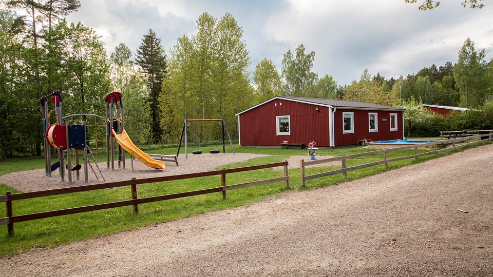 Överblick av Åkerlänna dagbarnvårdares skolgård och röd byggnad