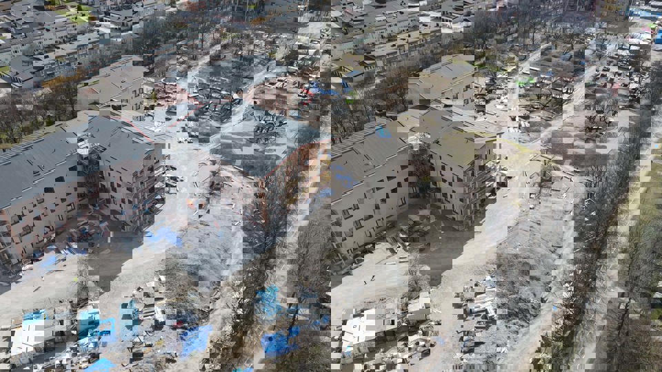 Flygbild över byggplats med omgivande bebyggelse