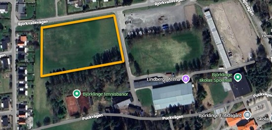 Satellitbild över ett gulinringat gräsområde nära en skola.