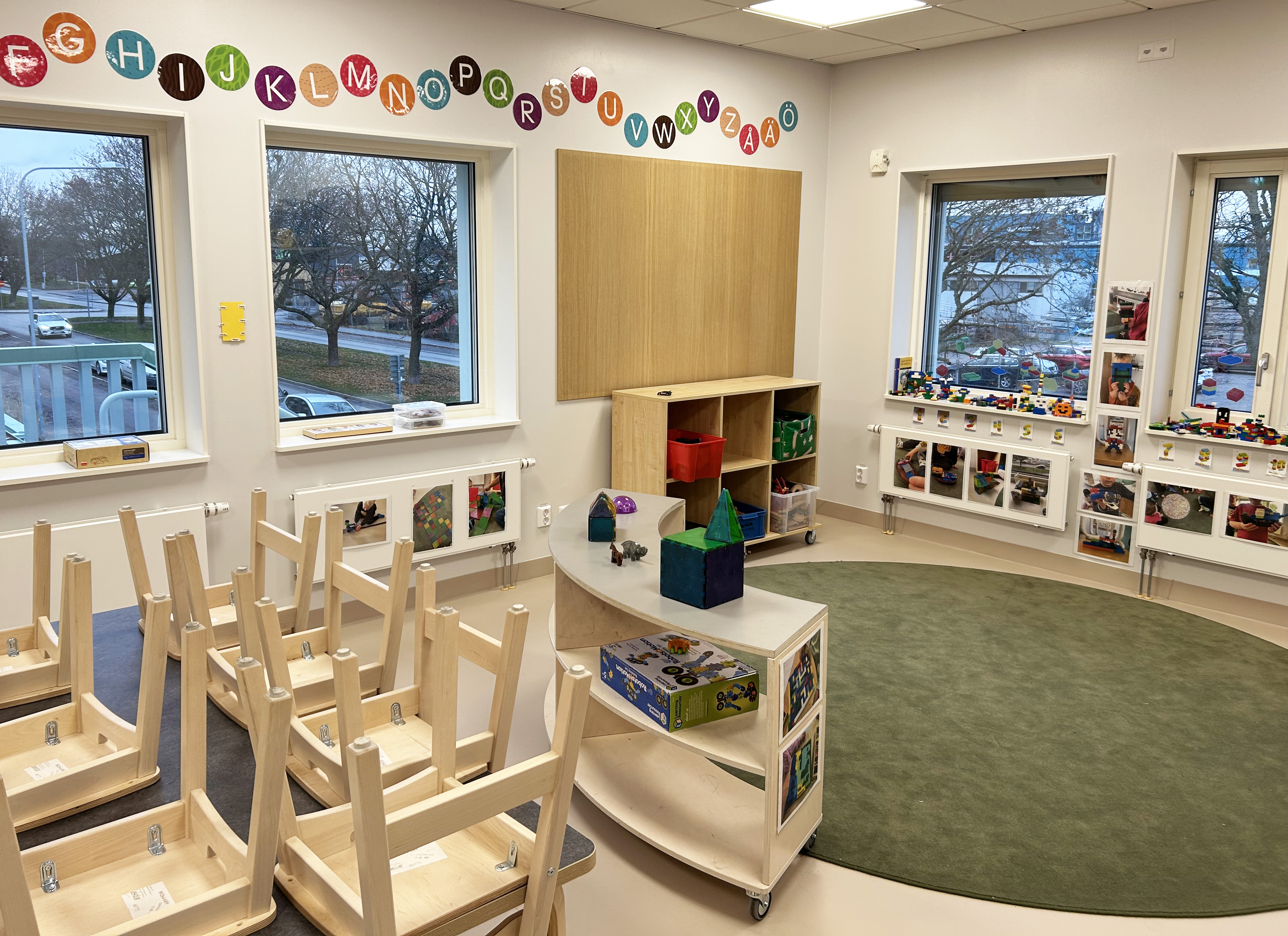 Ett förskoleklassrum med stolar upp och leksaker vid ett fönster.