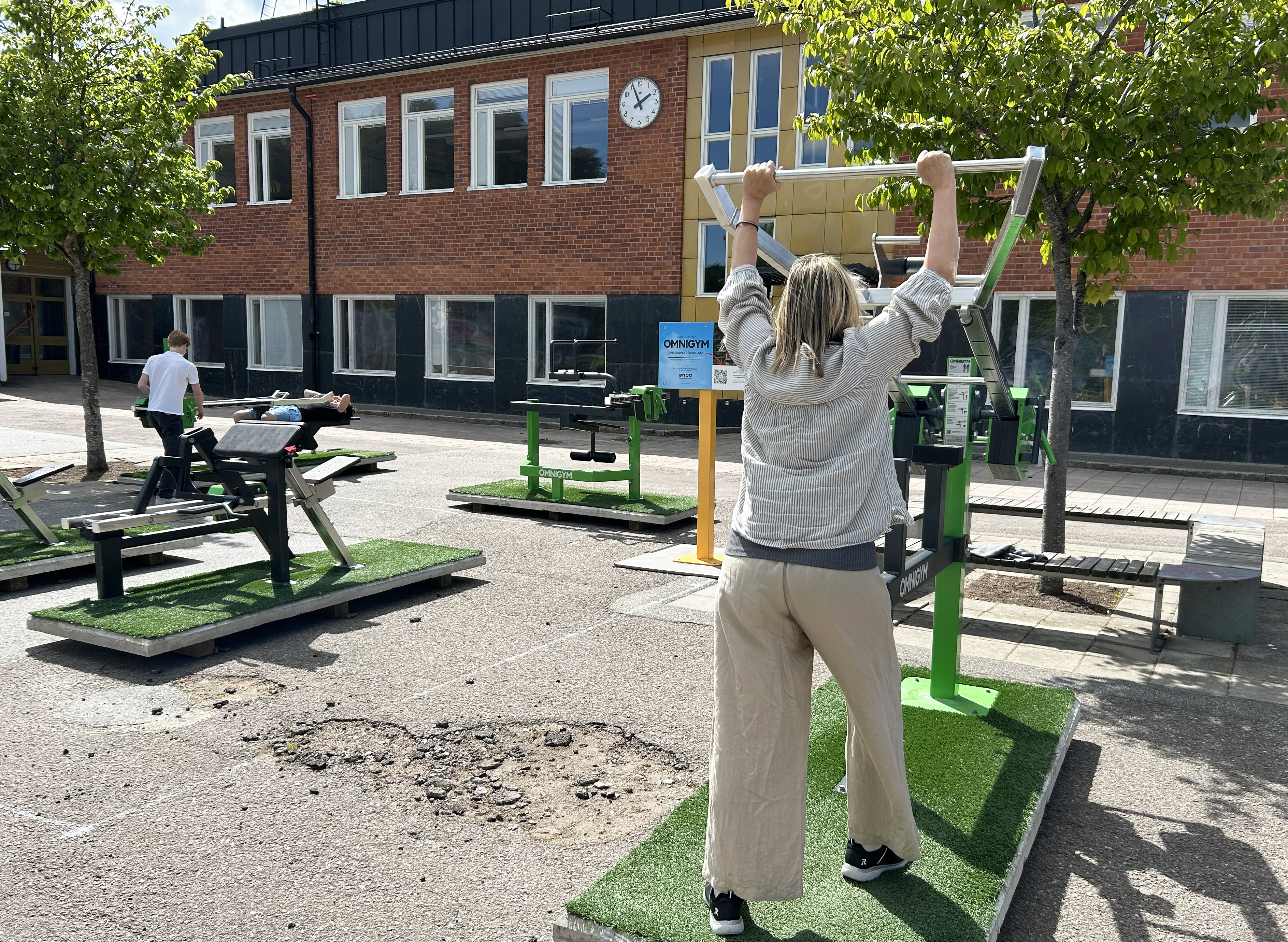 Träning i utegym på skolgård. 