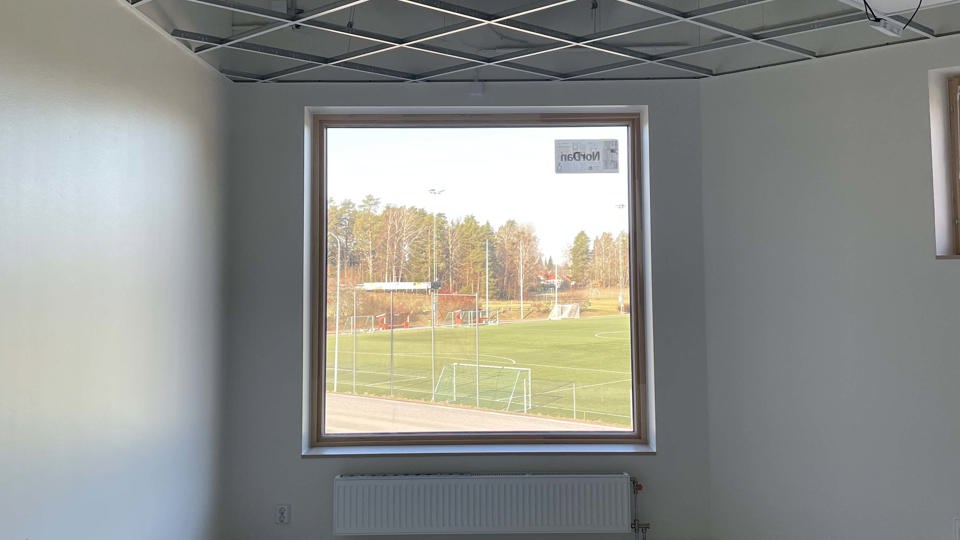Rum med fönster åt en fotbollsplan i en ny förskola som är under uppbyggnad.