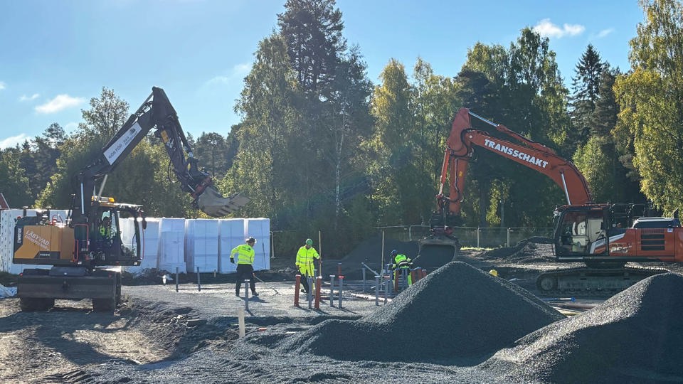 Byggplats och arbetare med grävmaskiner vid bygget av Bälingeby förskola.