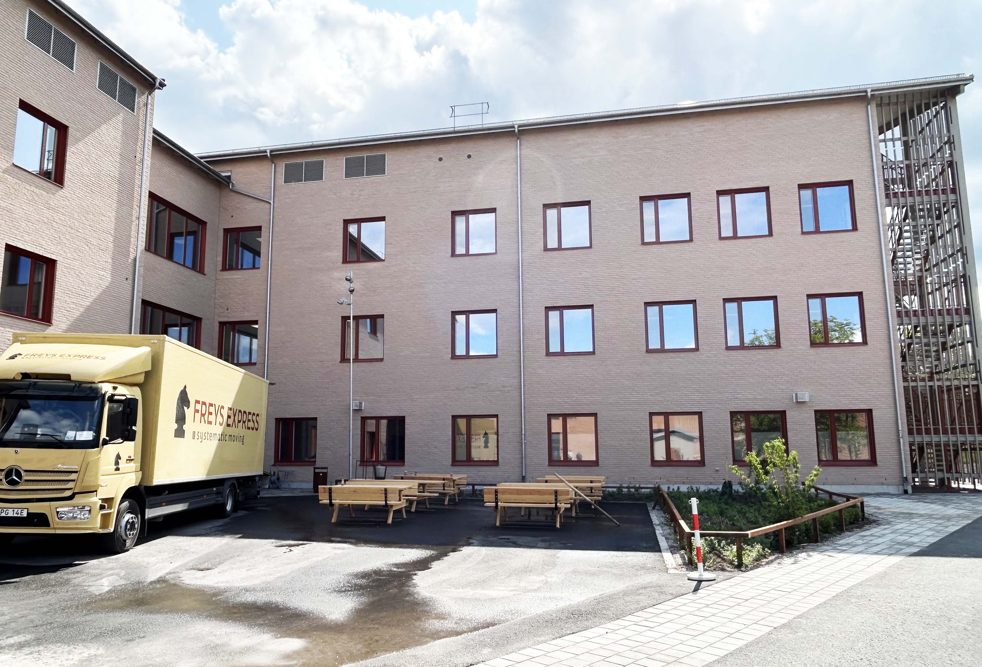Flyttbil framför nybyggd skolbyggnad,