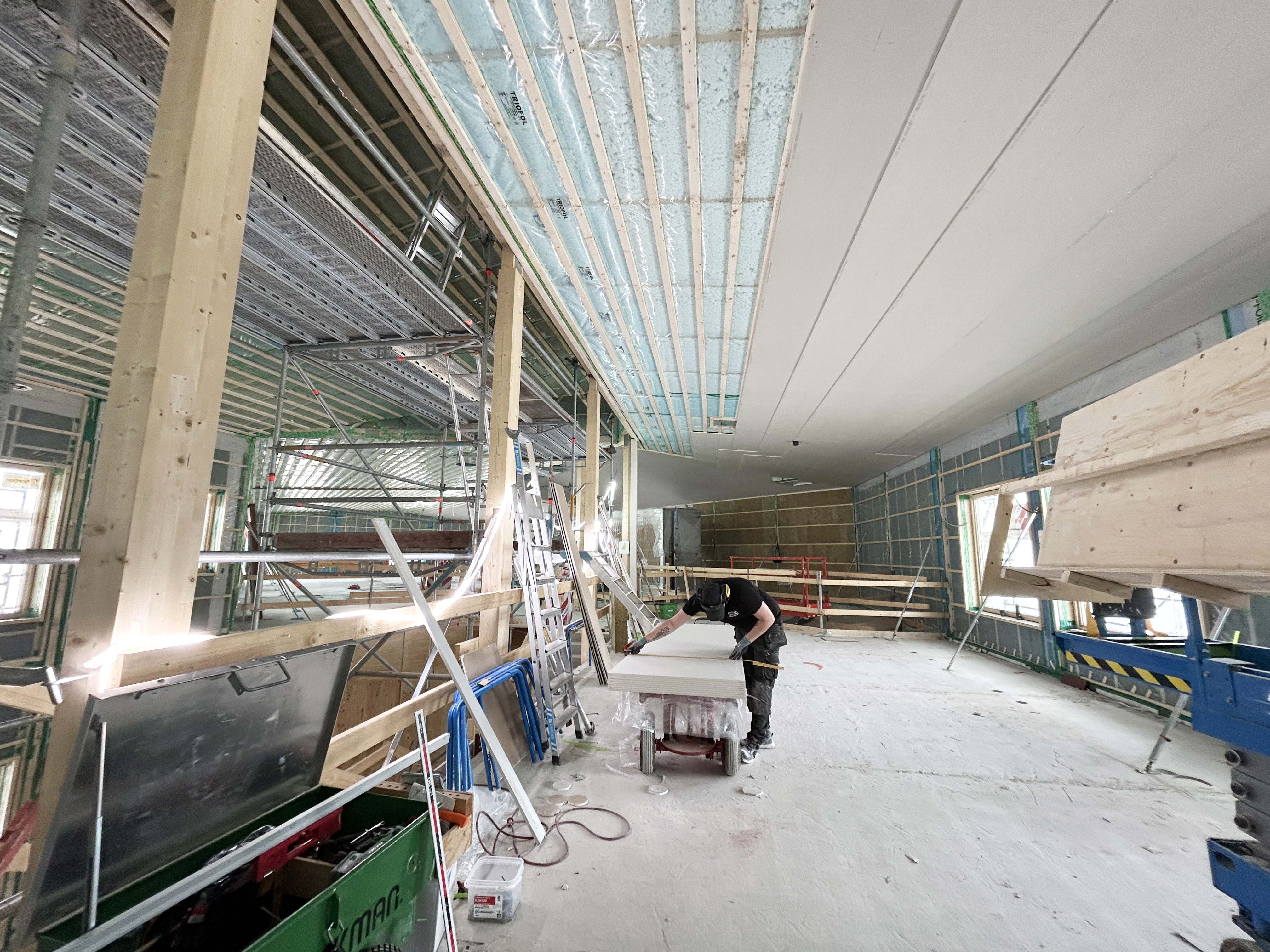 Byggnadsarbetare med verktyg arbetar inuti en blivande förskola.