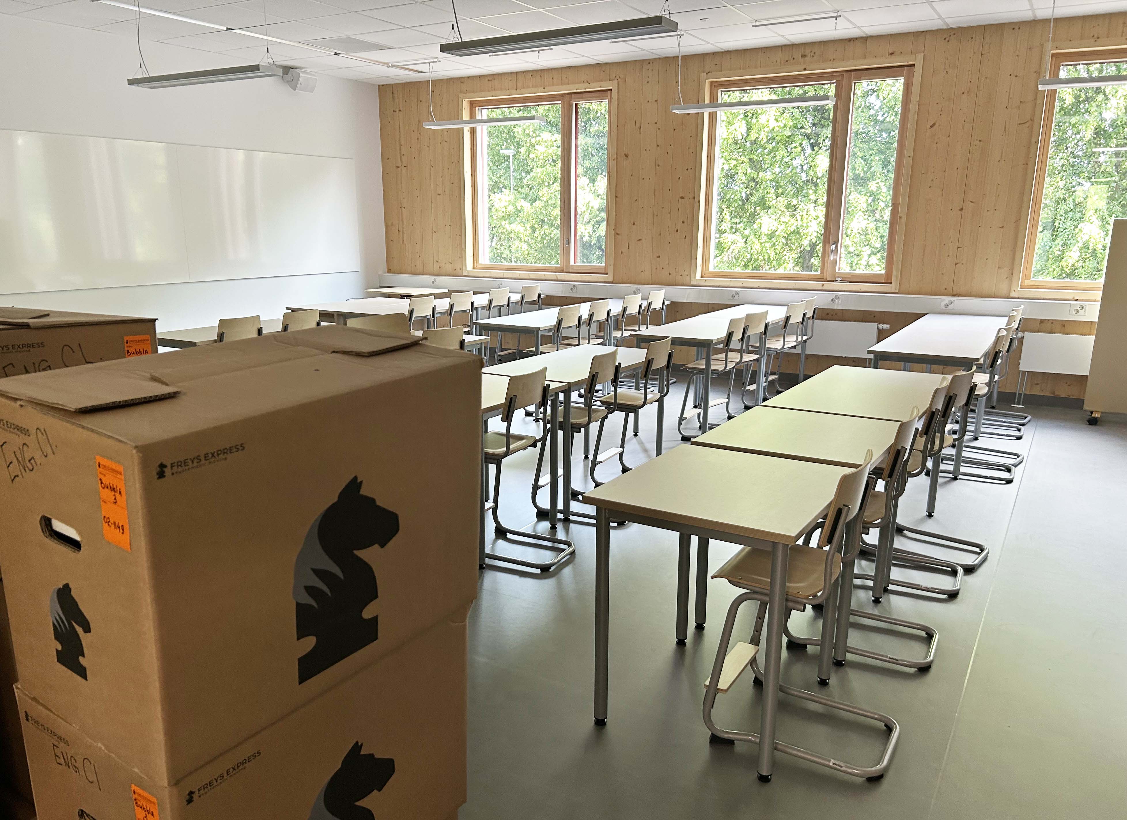 Flyttkartonger som står i ett nybyggt klassrum.