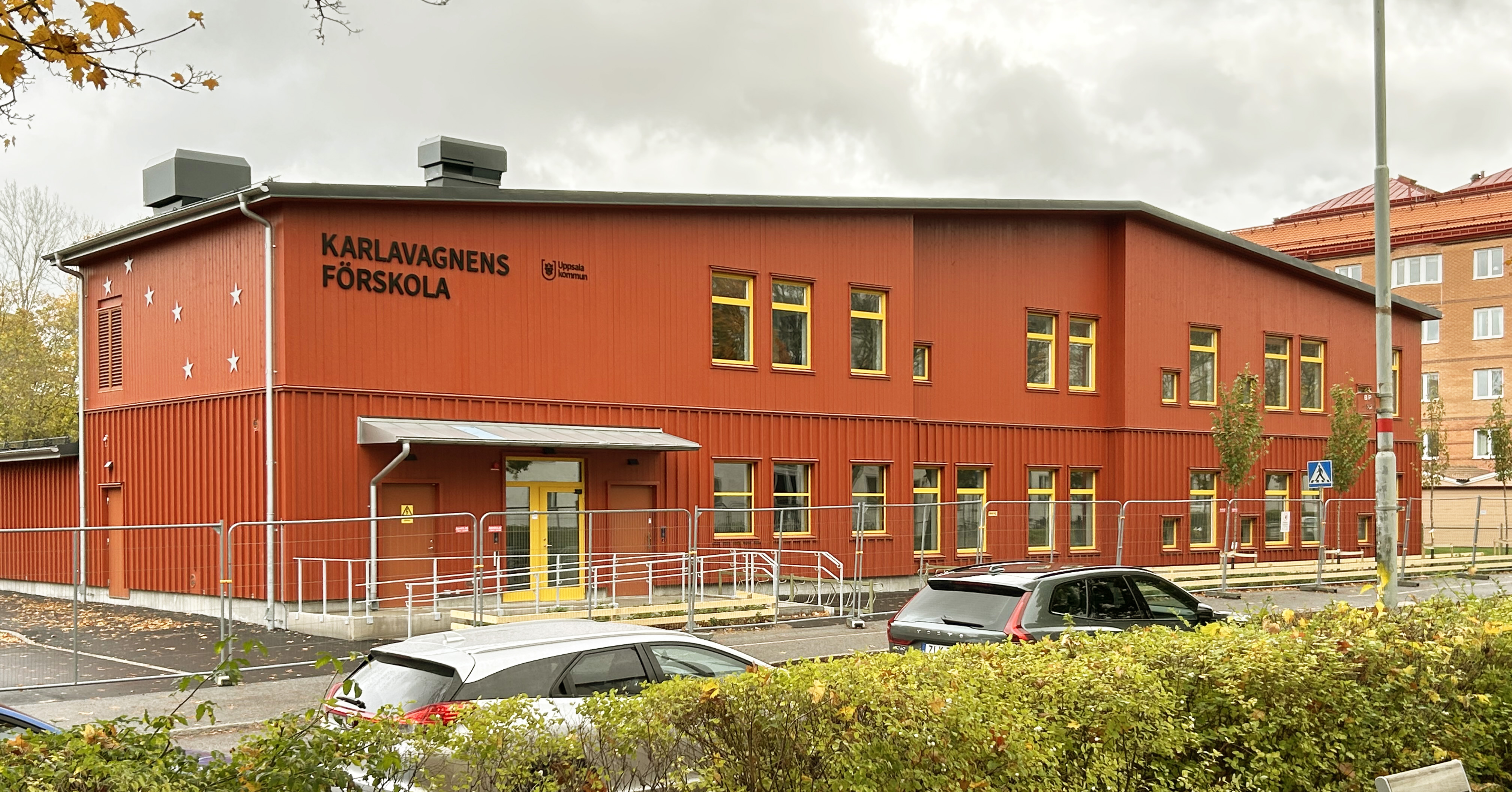 Nybyggd röd förskola med en väg i förgrunden.
