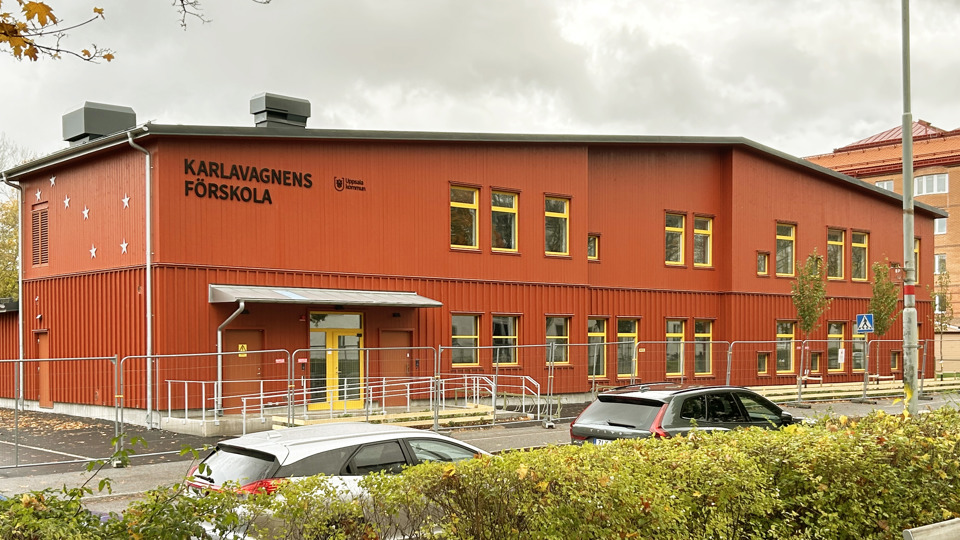 Nybyggd röd förskola med en väg i förgrunden.