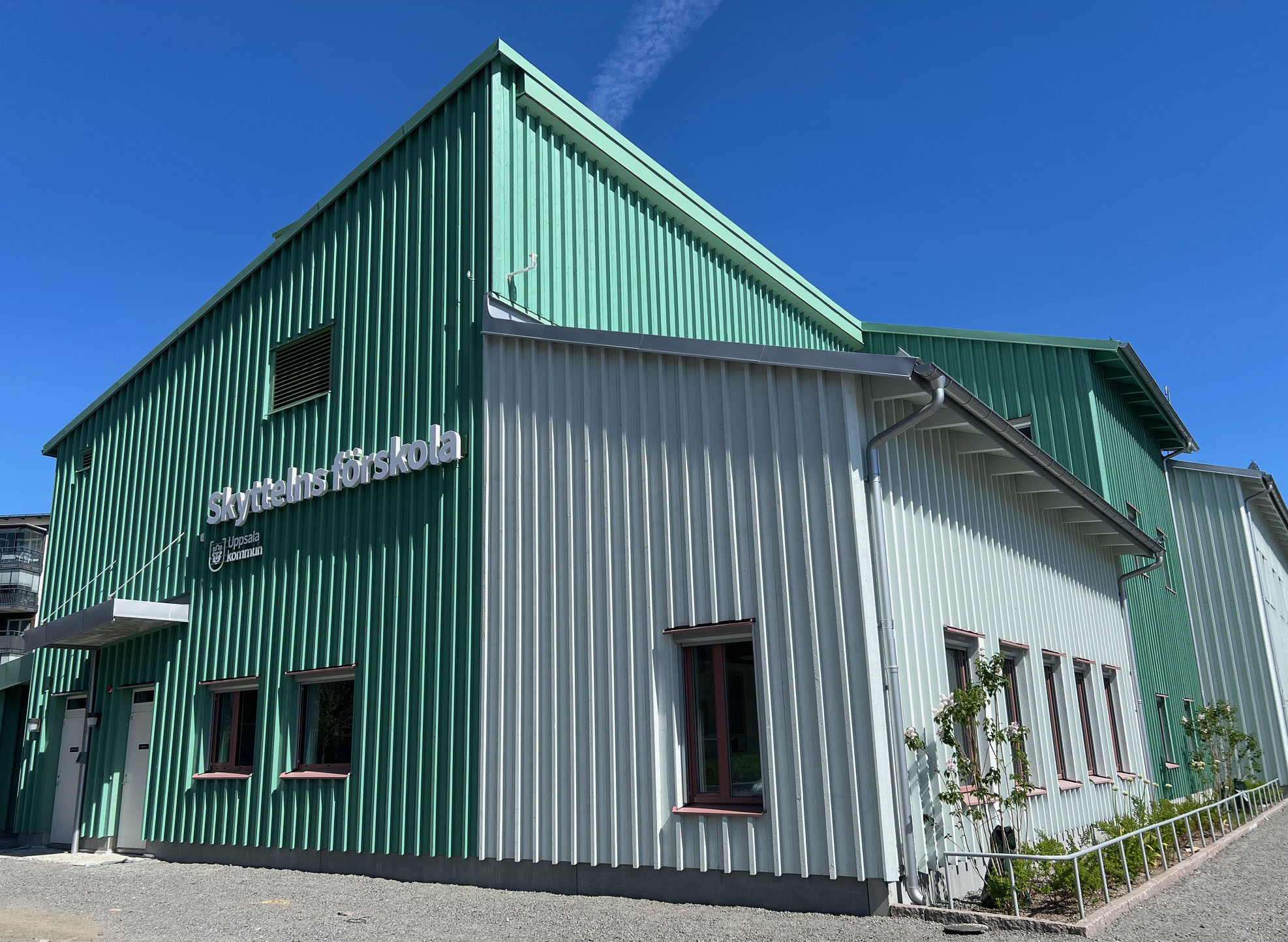 Nybyggd förskola med grön träfasad.