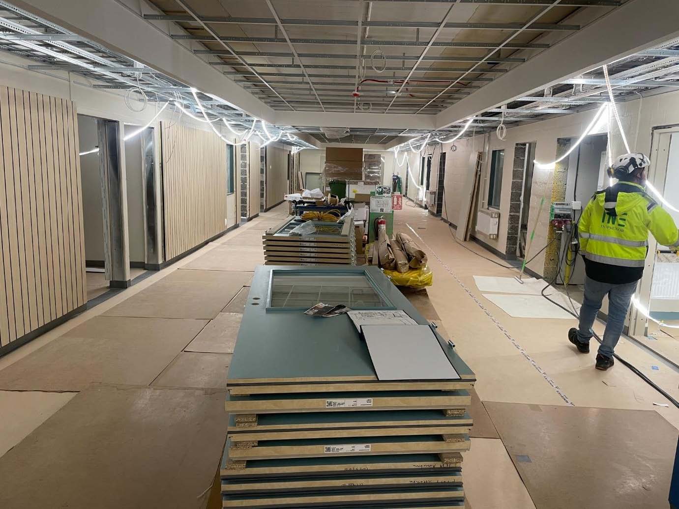 Invändig pågående renovering av skola där nytt golv lagts och innerväggar monterats.