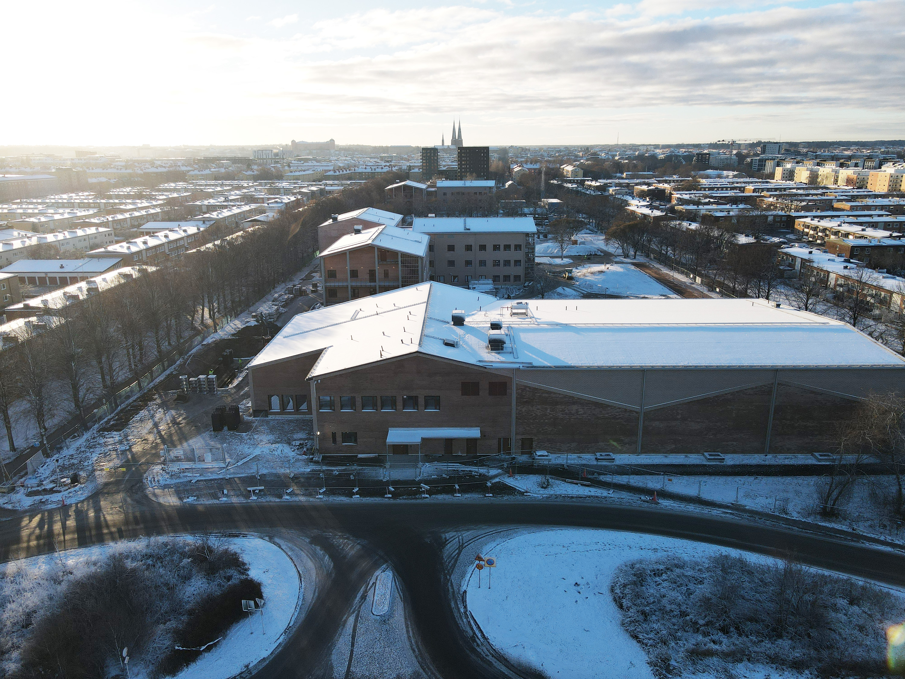Flygfoto av byggplats för skola som är täckt av snö.