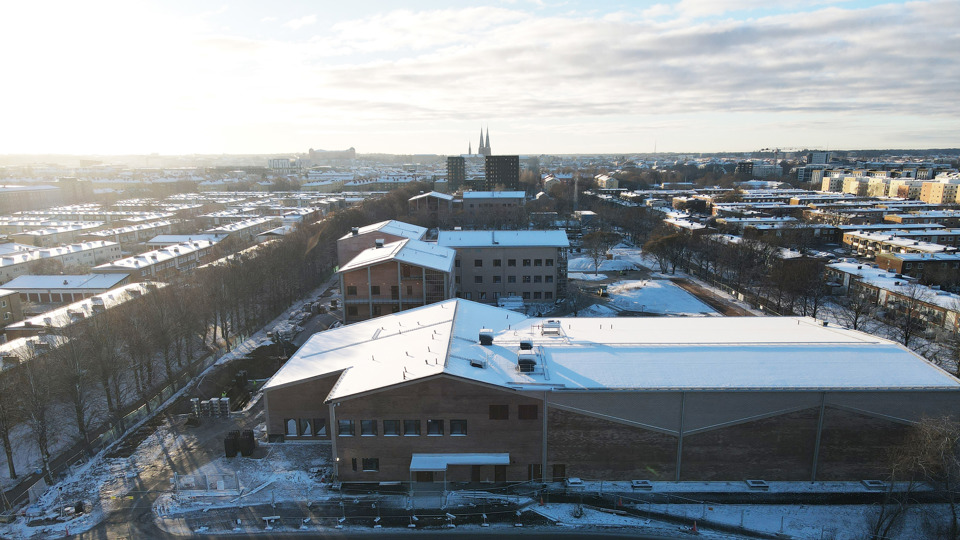 Flygfoto av byggplats för skola som är täckt av snö.