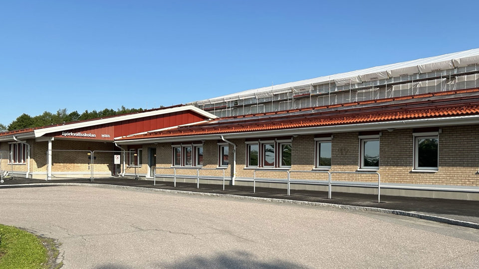 Fasadbild på skola som renoveras med presenning på taket.