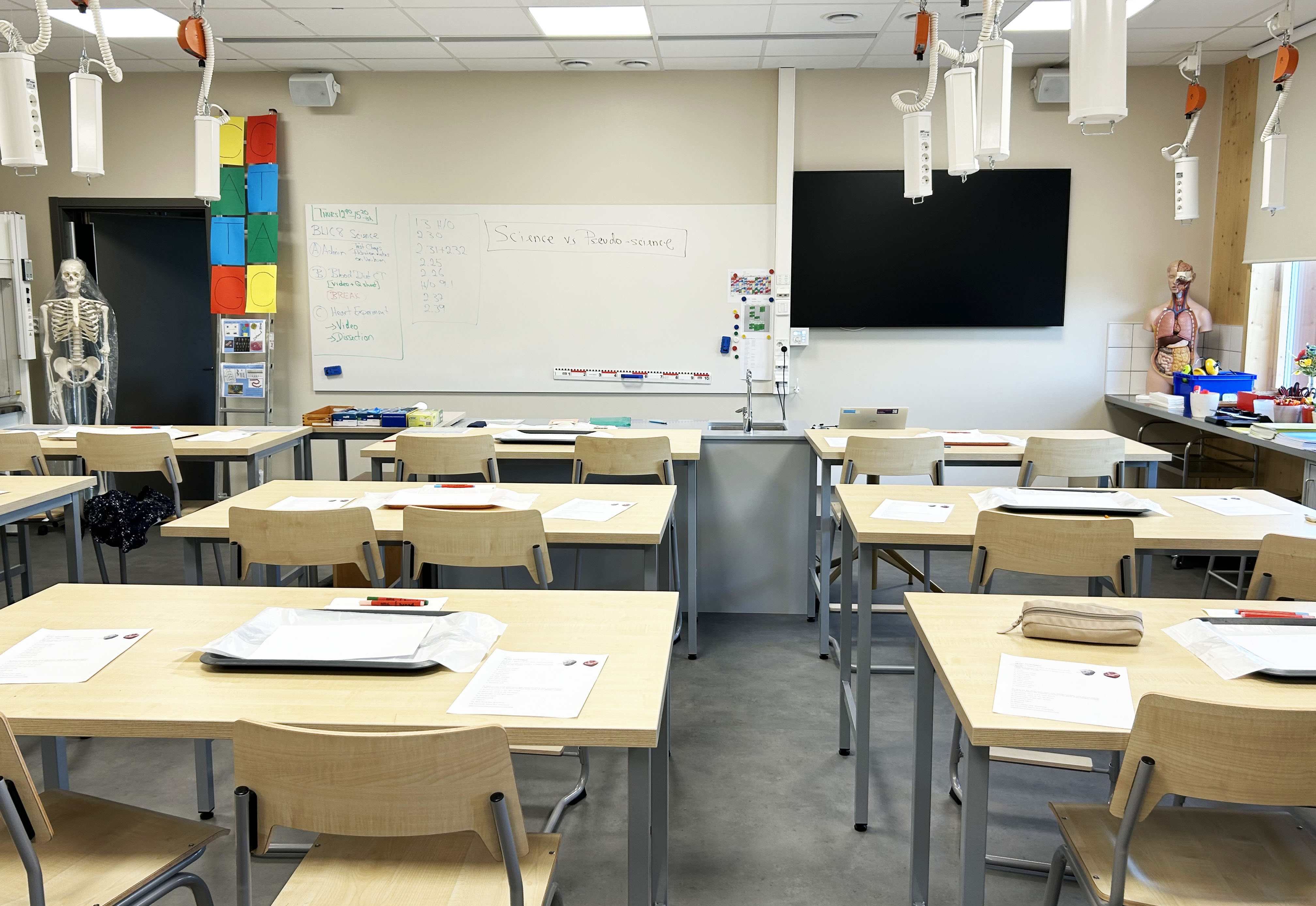 Klassrum med bänkar och papper i nybyggd skola.