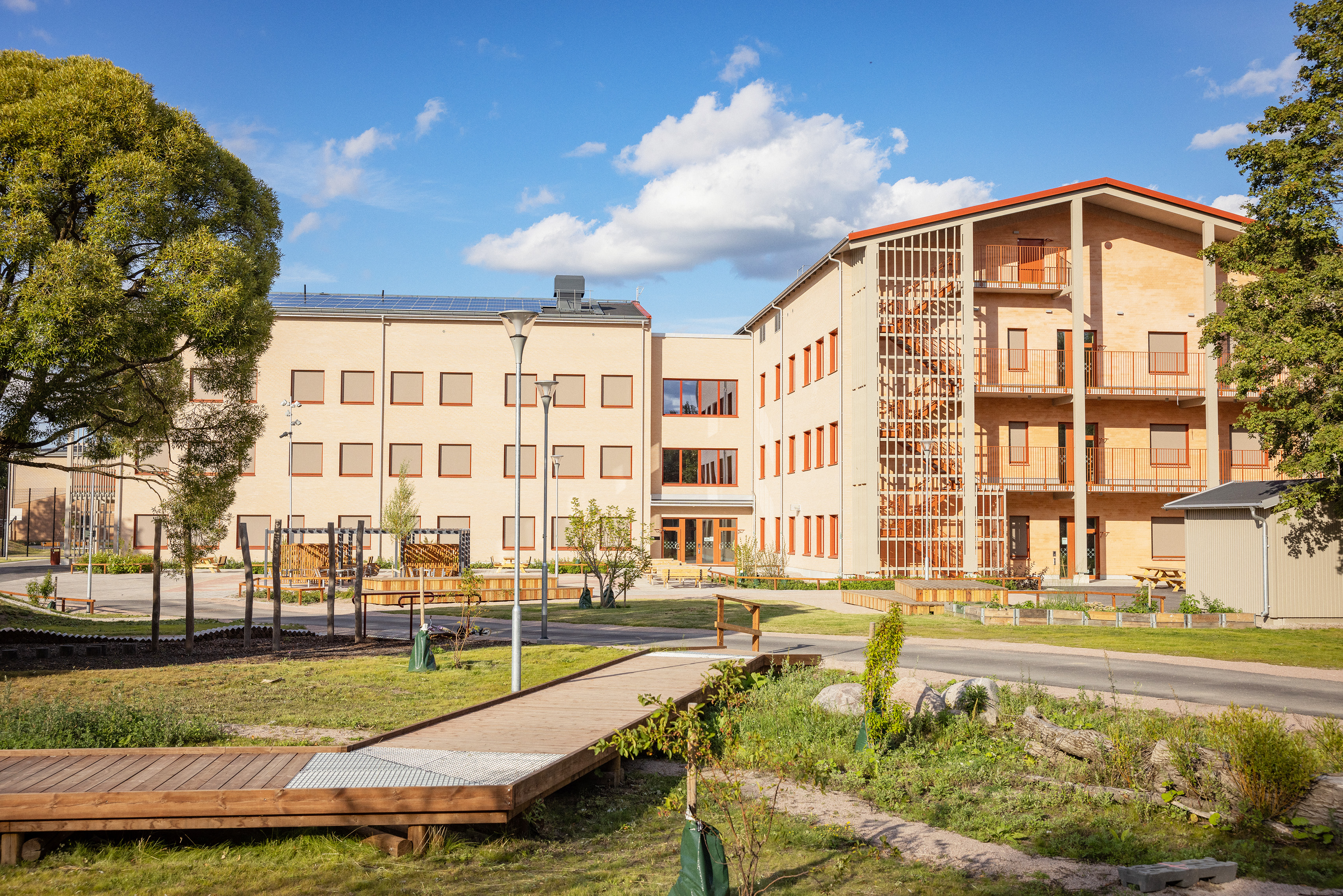 Ny skola med lekutrustning i förgrunden.