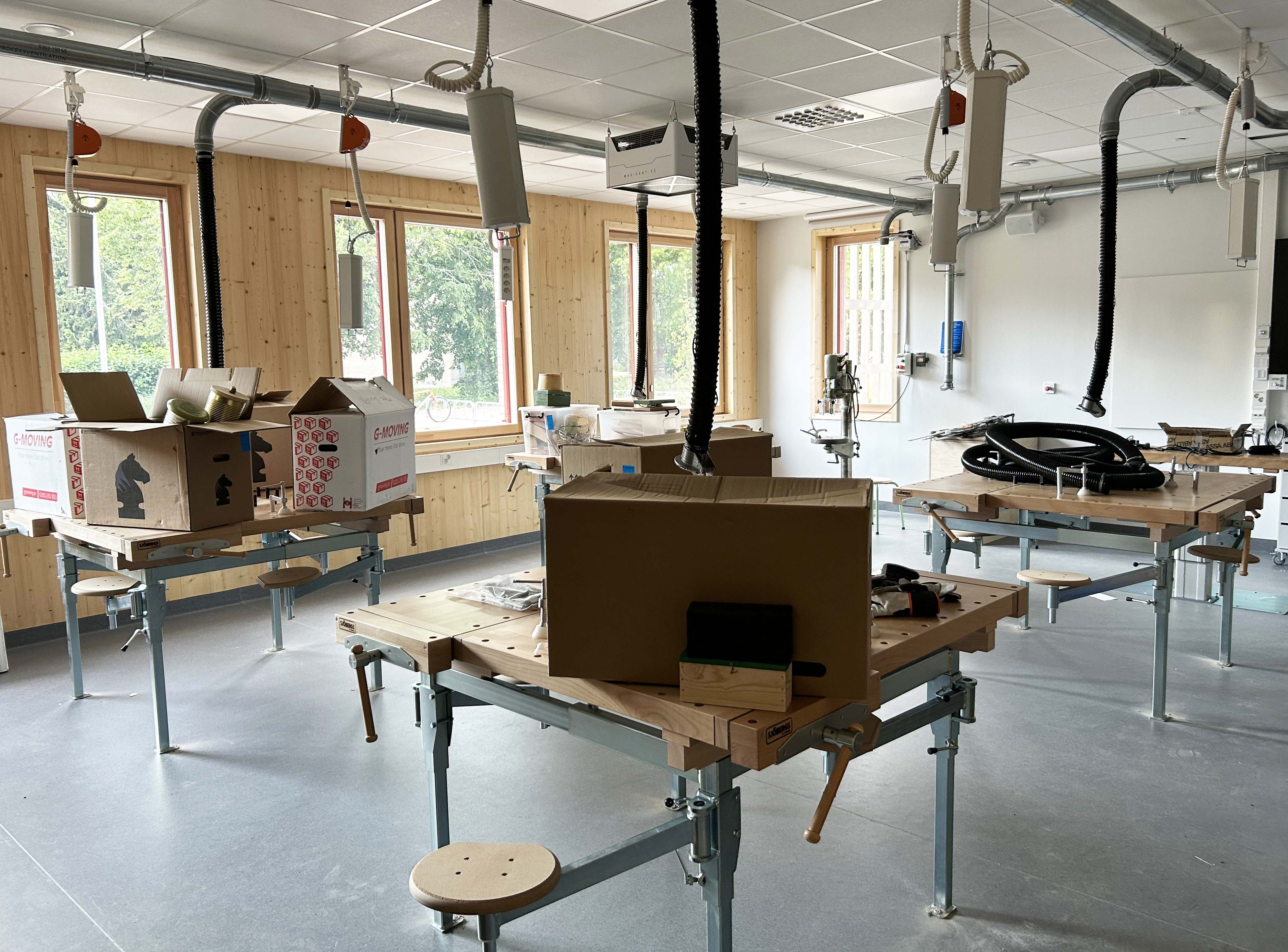 Flyttlådor som står i en nybyggd träslöjdssal.